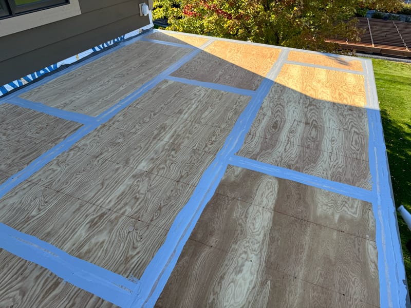 Plywood deck seams and fastener lines sealed with liquid-applied flashing.