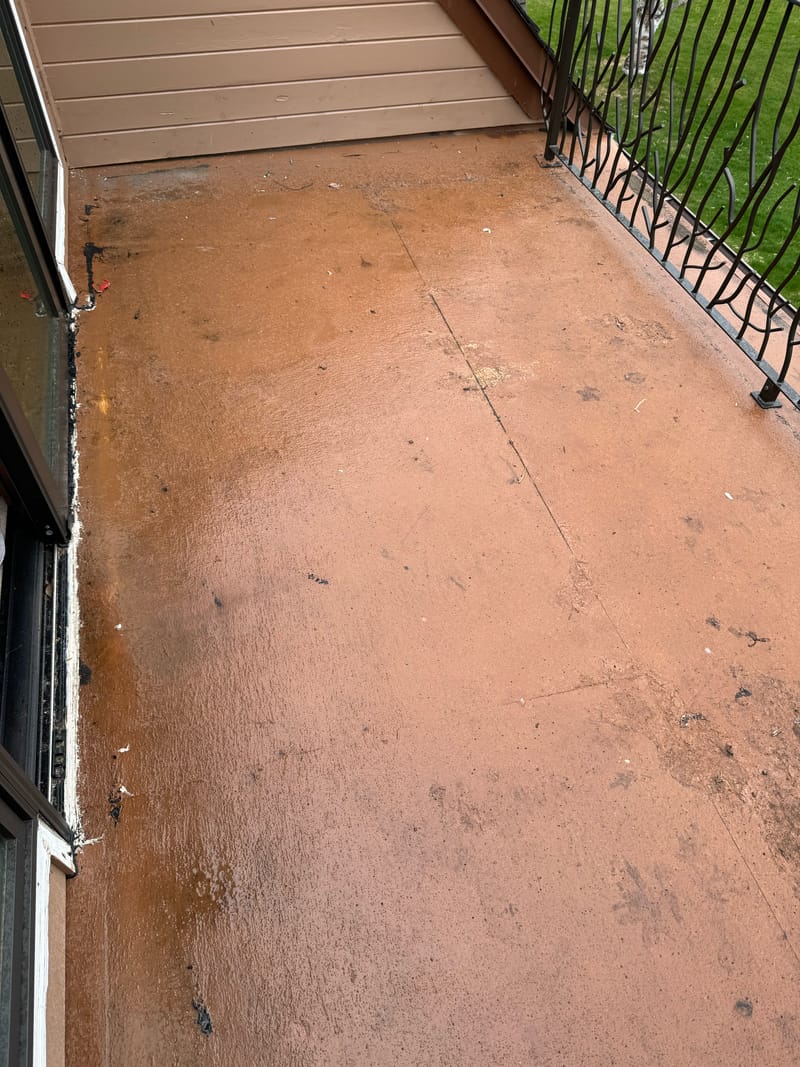 Worn, cracked balcony deck coating before the rebuild.